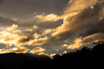 golden sunset clouds with light shining through shot over the mountains
