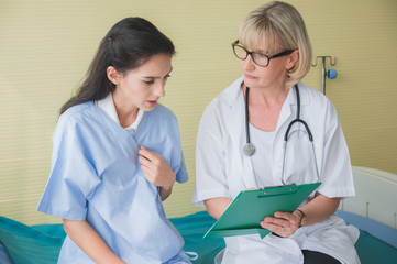 Fototapeta premium Senior female doctor meet the patient discussing consultation and making notes about symptom problem. Health care and client service in medicine concept.