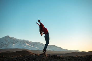 Young active girl in winner pose in mountains