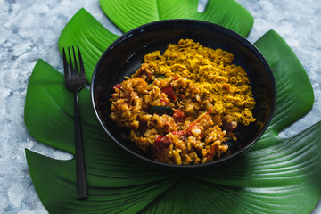 plant-based food, vegan scrambled tofu with mediterranean veggies and potatoes on leaf-shaped placemat