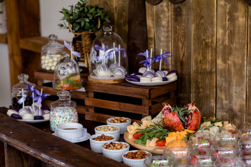 buffet for a birthday or wedding. Delicious wedding reception, dessert table, cheese bar. wooden details at a wedding