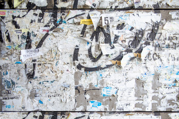 old flyers on the wall of ads with graffiti