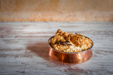 Chicken biryani in a copper dish