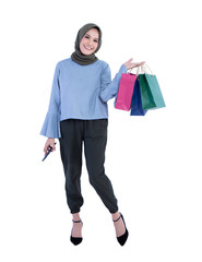 Beautiful women of Muslim Indonesian holding cell phone and carrying a shopping bag isolated on white background