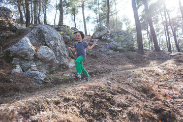 A boy runs along a mountain path.
