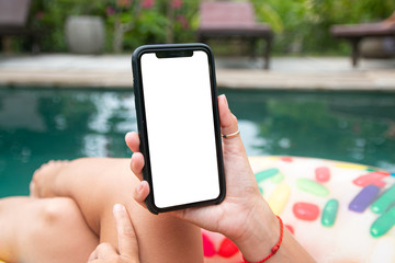 Smartphone screen that a girl holds in her hand on vacation in the pool