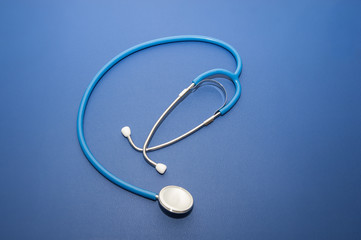 Metal  stethoscope on blue background isolated