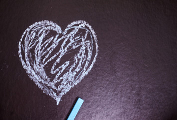 Heart drawn in chalk on a black background.