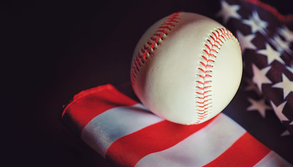American traditional sports game. Baseball. Concept. Baseball ball and bats on a table with american flag.