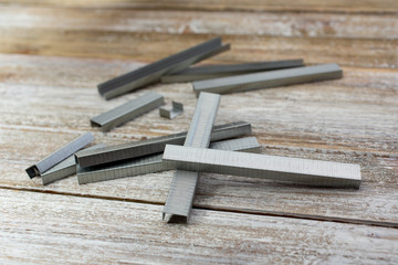 A view of a several strips of staples on a wooden surface.