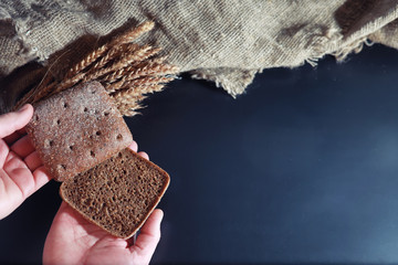 Fresh loaves of bread with wheat and gluten on a black table. Bakery and grocery concept. Fresh,...
