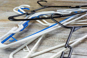 A view of a pile of plastic hangers on a wooden surface.