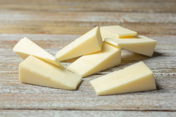 A closeup view of a pile of cosmetic wedge sponges, on a wooden surface.