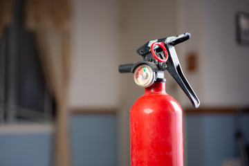A view of a fire extinguisher in a living room setting.