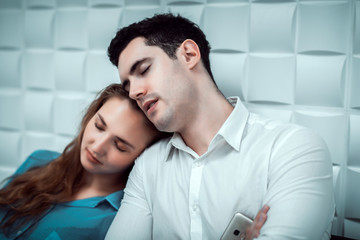 Young married man and woman sitting on chair and sleeping together on white background.  couple lover concept