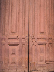 old wooden door to the monastery close up in maroon color