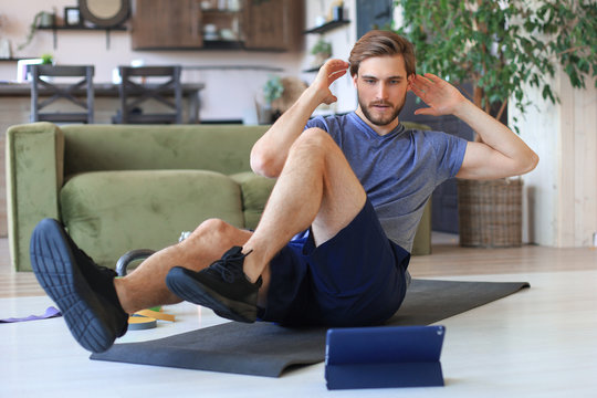 Handsome Man Doing Abs Exercises At Home During Quarantine. Concept Of Healthy Life.