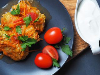 Cabbage rolls with meat, rice and vegetables. Stuffed Peking cabbage leaves with meat, in tomato sauce, on a black plate. . Chow Farchi, dolma, Sarma, cabbage rolls or golabki. Top view,