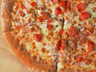 pizza Margarita close-up on parchment. Italian dish with tomatoes cheese and herbs