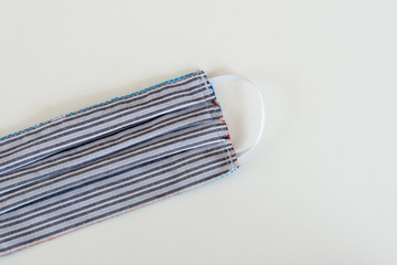 Masque en tissu avec élastiques oreilles fabriqué main sur fond blanc