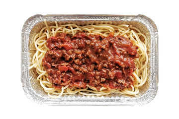 Spaghetti bolognese in aluminium foil box isolated on white background.  Selective focus.  Concept...