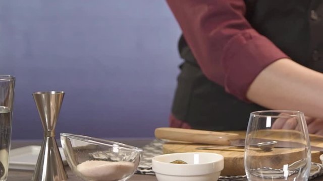 taking a silver jar with a muddler on chopping board - static