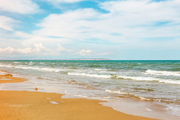 Fototapeta na wymiar Seascape with weaves breaking on a sandy beach in Guardamar, Alicante. Spain