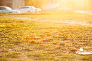 in the meadow are sports equipment: tennis rackets, badminton rackets, jump rope