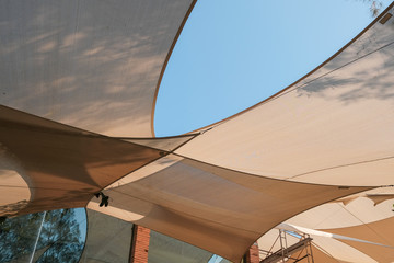 Big white canvas umbrella with blue sky background. Big white canvas roof background with clear sky.