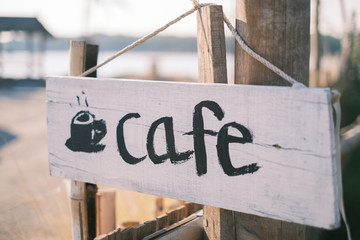 Cafe sign and billboard with rope hanging on the wood post