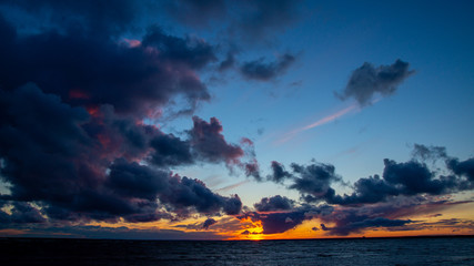 Sunset on the beach, waves, dramatic sky, dramatic clouds.