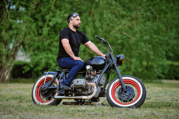 Obraz na płótnie Canvas Biker leaning on a motorcycle enjoying the view