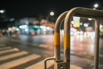 Iron fence isolated from traffic lights background in the night. Blur street background.