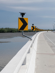 Road sign warn drivers for ahead dangerous curve road on coastal winding road