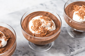 Vegan avocado, banana and cocoa mousse. Topped with coconut whipped cream and dark chocolate. White...