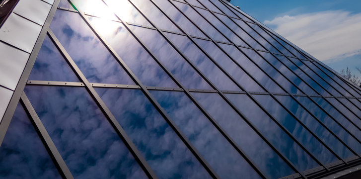 Hausfront Fasade aus Glas vor blauem Himmel