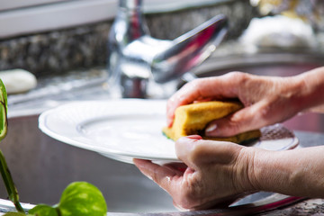 woman washing dishes with scouring pad