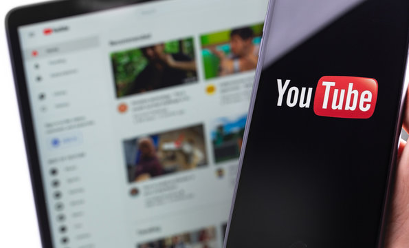YouTube logo on the screen smartphone and YouTube homepage on the display laptop. YouTube is a free video sharing application that anyone can watch. Moscow, Russia - April 20, 2020