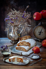 Apple strudel roll with caramelized apples wrapped into phyllo dough with nuts, cinnamon and raisins. Served on a silver plate with sauce. Still life