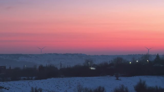 Wind generators on winter dusk landscape