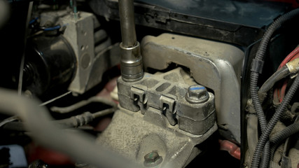 Close up screwing tightly car engine bolts. Crank bolt wrench fixing a car engine.