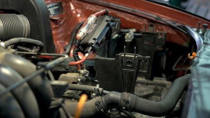 Professional mechanic repairing car engine. Close up hands of a repairman are fixing car motor.