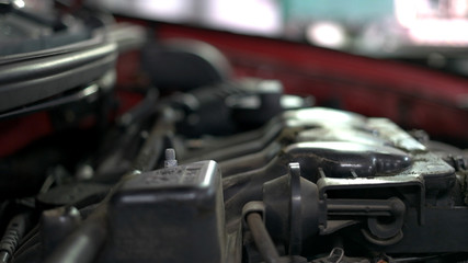 Fototapeta premium Mechanic is unscrewing car engine detail. Close up hands of a car service worker.