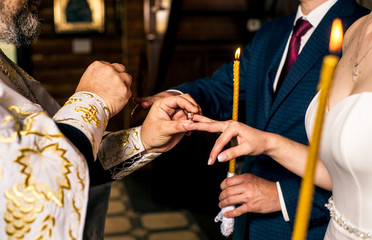 a couple exchanges rings in a church close-up