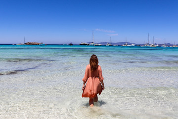 Beautiful woman walking in the ocean in Formenterra Ibiza Spain