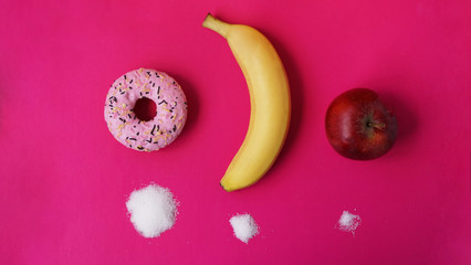 Choose healthy fruits instead of unhealthy sweets with huge quantity of sugar - pink background