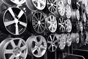 Alloy wheels on rack in auto store. Black and white effect