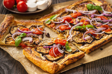 Eggplant tart with tomatoes , red onion and cheese.