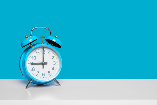 Blue Vintage Alarm Clock At Nine O’ Clock On A Blue Background With Space For Copy