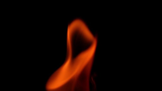 Powerful flame of fire burning in slow motion on a black background.